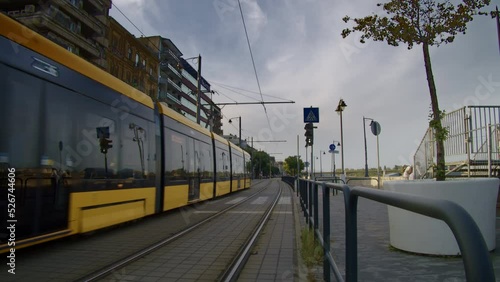 A passenger tram runs in Budapest, Hungary. The flashing of the traffic light changes. In the background you can see vehicles.