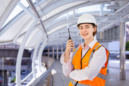 Caucasian woman engineer is using walkie talkie while inspecting the construction project for modern architecture and real estate development concept