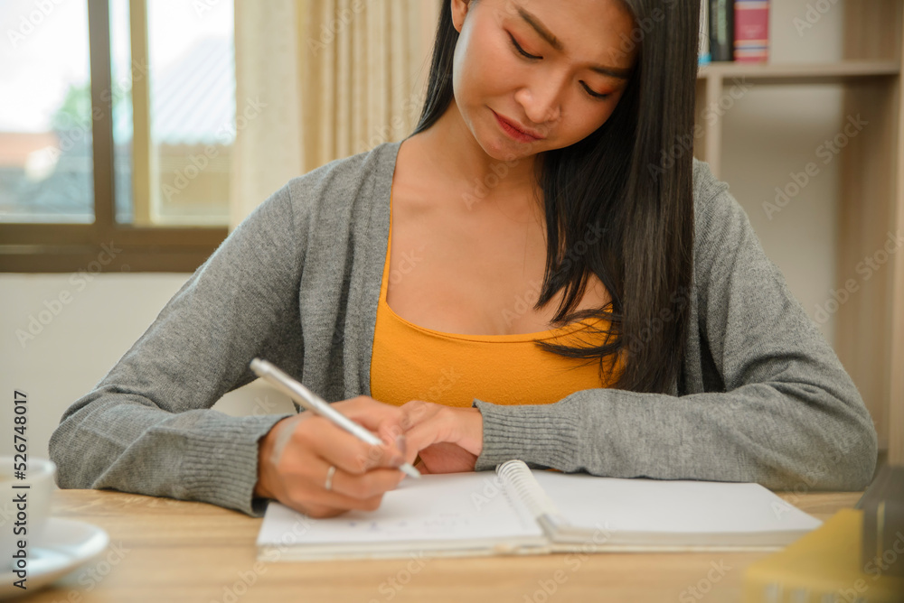 Planner plan Schedule Calendar and reminder agenda, work at home. Woman hand planning daily appointment and writing business trip in diary book at office desk. 2023 Calendar reminder event concept.