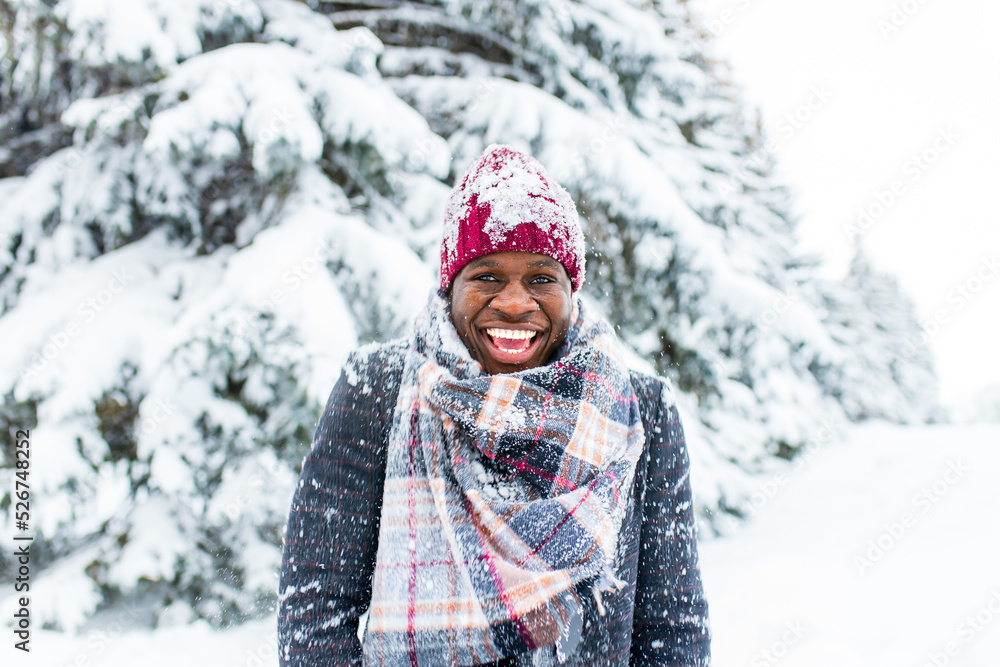 african american handsom man in red hat and stylish plaid coat look at camera with toothy snow- white smile outdoor in park african american handsom man in red hat and stylish plaid coat look at camera with toothy snow- white smile outdoor in park