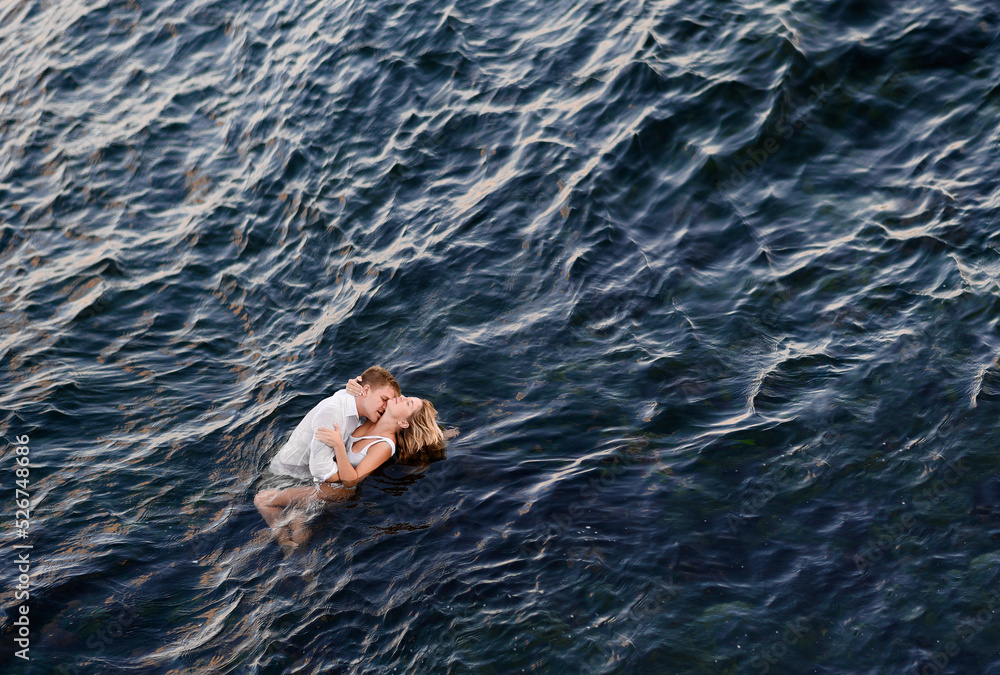 Bride And Groom Hugging In Ocean Water And Kissing