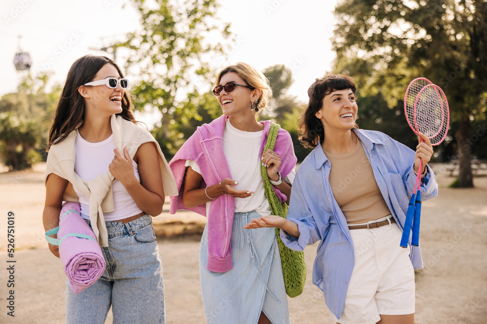 Nice caucasian young ladies friends have fun spending weekend outdoors in summer. Girls wear sunglasses, casual clothes. Relaxation concept Nice caucasian young ladies friends have fun spending weekend outdoors in summer. Girls wear sunglasses, casual clothes. Relaxation concept