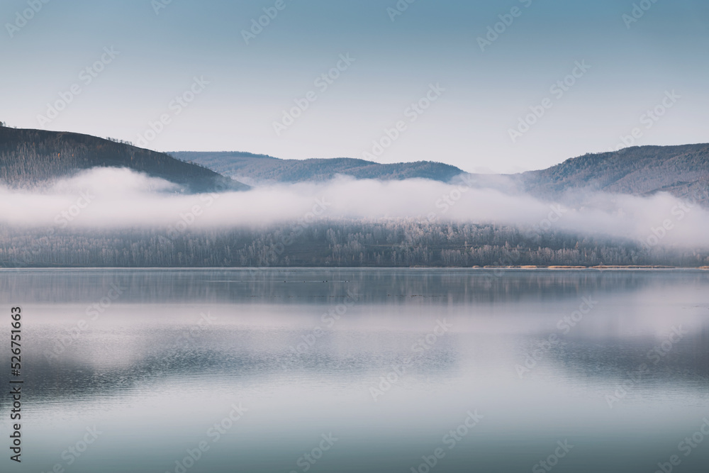 Mountain lake with clouds in foggy morning. Autumn landscape.