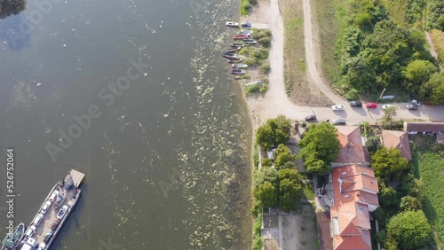 Aerial drone shot of old ferry with the vehicles on it,  on Danube river -  Approaching the coast