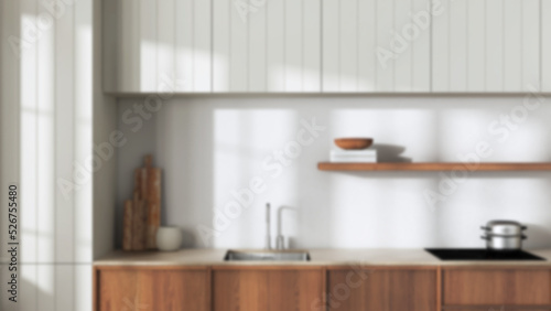 Blurred background, japandi wooden kitchen close up. Modern cabinets, wallpaper, shelf with decors and sink. Minimalist interior design