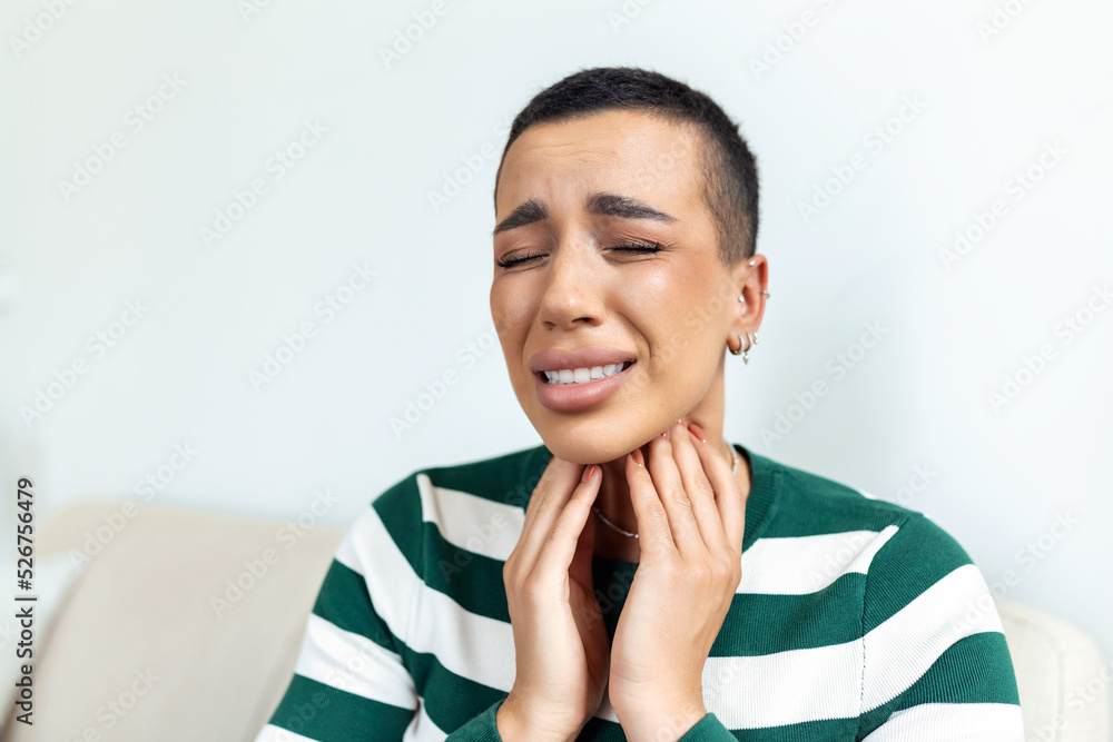 Sick day at home. Young woman has sore throat and common cold. Cough