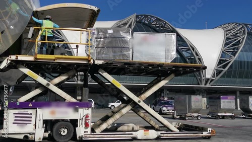 Air cargo logistic containers are loading to an cargo airplane at the airport.