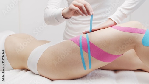 Therapist is applying tape to female body. Physiotherapy, kinesiology and recovery treatment.