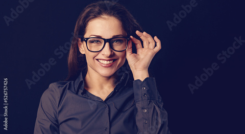 Beautiful thinking toothy smiling business woman in blue shirt on black background with empty copy space for text. Closeup