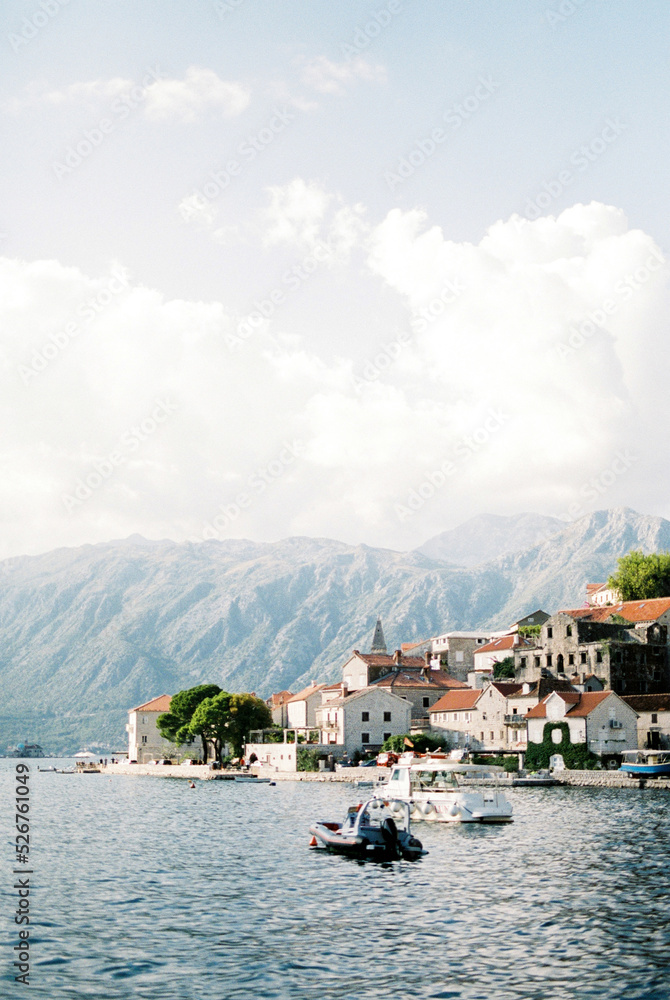 Ancient houses on the coast of Perast over the Bay of Kotor against the backdrop of mountains
