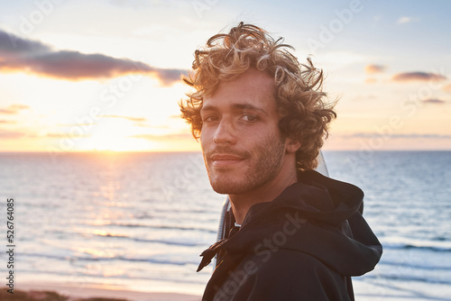 Photography Man looking at the camera with pleasure smile while posing at beach