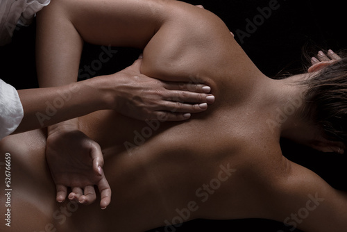 masseur girl makes a massage close-up on a dark background. close-up massage