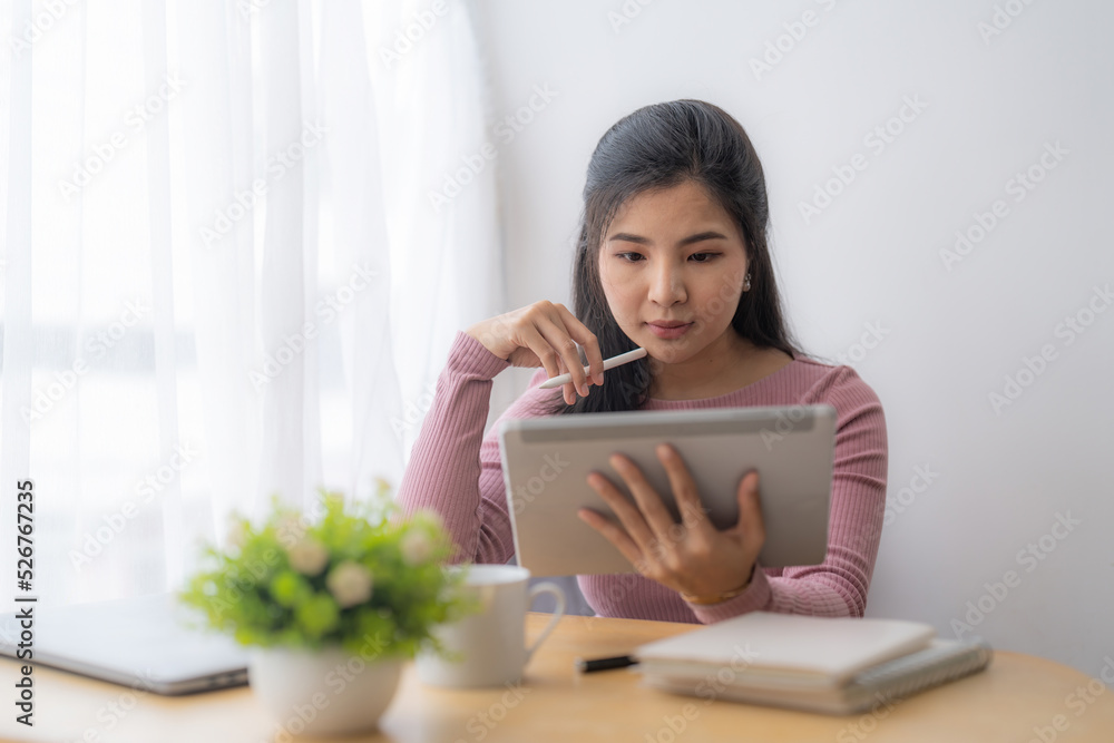 Young asian woman using digital tablet at home. Online learning, home school concept. Young asian woman using digital tablet at home. Online learning, home school concept.