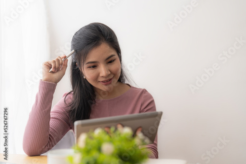 Young asian woman using digital tablet at home. Online learning, home school concept.