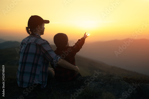 Fototapeta Naklejka Na Ścianę i Meble -  Mom with son in the autumn mountains during sunset. Travel with child concept