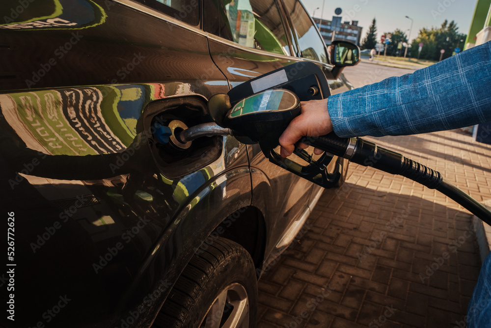 Φωτογραφία Shot of man driver filling his car in gas station outdoors in city