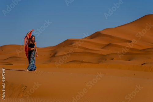 A Beautiful Model Poses In The Sand Dunes In The Great Sahara Desert In Morocco, Africa photo