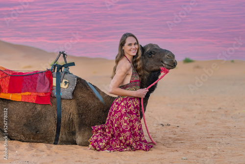 A Lovely Model Rides A Dromedary Camel Through The Saharan Desert On Their Camels In Morocco photo