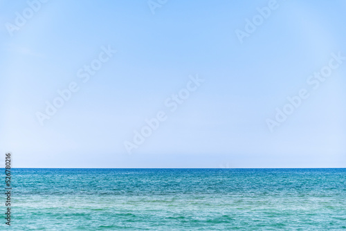 calm sea during summer with large copy space in the light blue sky, Ghisonaccia, Corsica, France, horizon over water