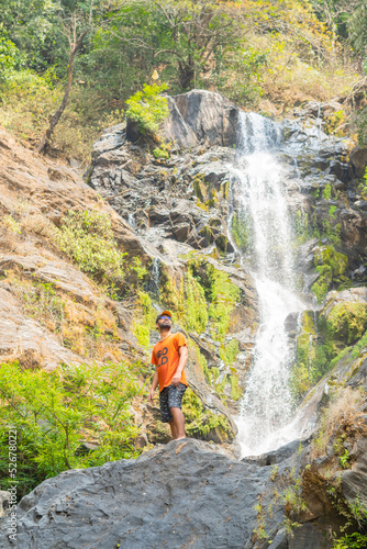 Young tourist standing in front of vibhooti water falls photo
