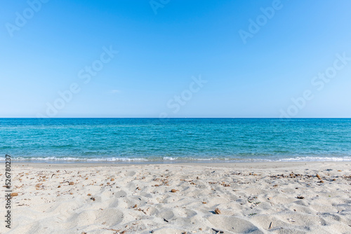 Fototapeta Naklejka Na Ścianę i Meble -  Sandy Beach and mediterranean sea during summer with large copy space, Ghisonaccia, Corsica, France. Horizon over water
