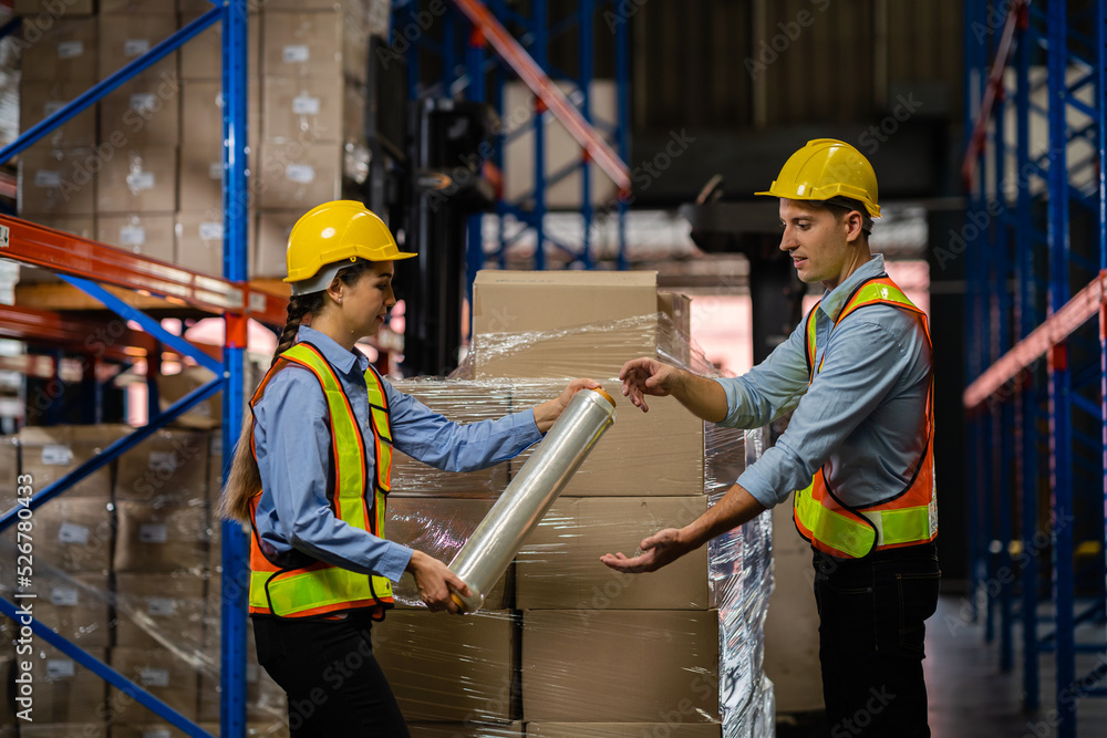 Workers wrapping boxes with stretch film at a warehouse warehouse. Work on logistics. Freight and distribution warehouse industrial labor concept. Industrial labor concept. Workers wrapping boxes with stretch film at a warehouse warehouse. Work on logistics. Freight and distribution warehouse industrial labor concept. Industrial labor concept.