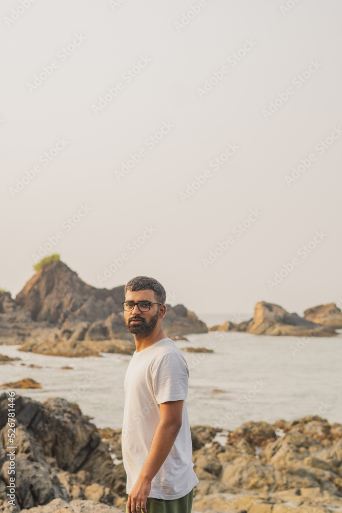 Young indian standing in front of om beach