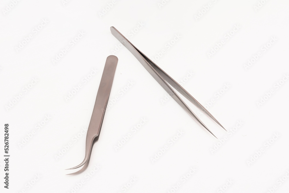 Tweezers and utensils for nail grooming on a white surface Tweezers and utensils for nail grooming on a white surface