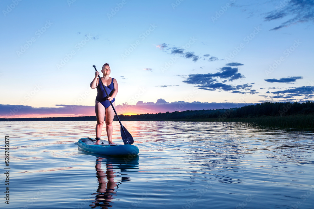 Woman in a swimsuit on a snowboard in the evening at sunset. Woman in a swimsuit on a snowboard in the evening at sunset.