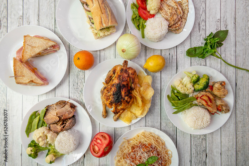Set of healthy food dishes with lots of steamed vegetables, steamed rice, charcoal grilled chicken, ham and cheese sandwich, fresh basil and grilled chicken fillet