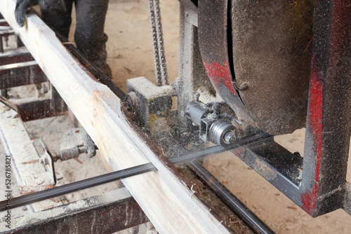 The process of sawing wood at the sawmill. Timber industry