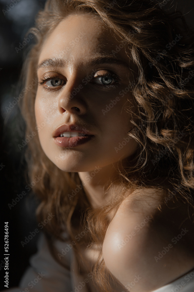 beautiful caucasian girl bride with curly red and blue eyes hair sits in a wedding dress and look at the camera. fashion portrait beautiful caucasian girl bride with curly red and blue eyes hair sits in a wedding dress and look at the camera. fashion portrait
