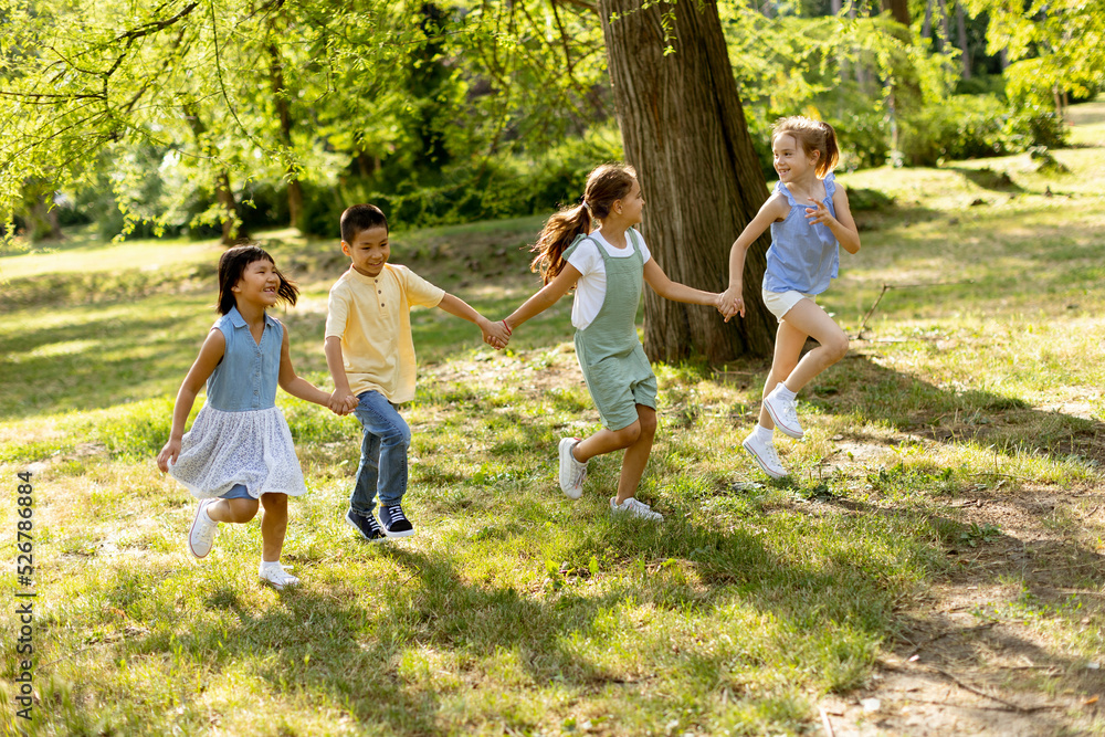 Fototapeta premium Group of asian and caucasian kids having fun in the park