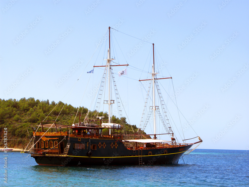 Fototapeta premium Beautiful vintage retro sailing ship sails on the sea against the blue sky 