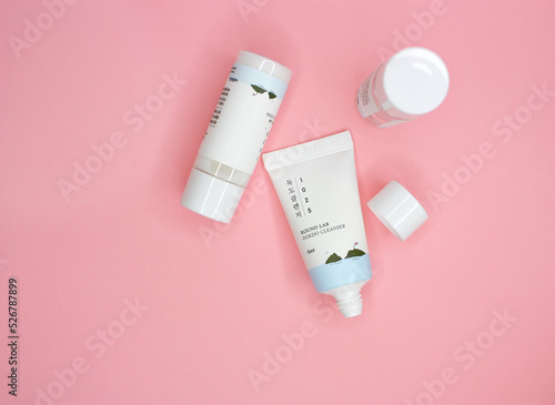 KYIV, UKRAINE - 19 AUGUST 2022: Flat lay set of travel size mini korean skin care products Round Lab, Dokdo tonic, cleanser and lotion. Pink background. Top view.