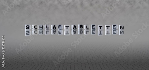 schlaftabletten Wort oder Konzept dargestellt durch schwarze und weiße Buchstabenwürfel auf einem grauen Horizonthintergrund
