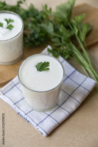 Ayran in a glass glass on a light brown background photo