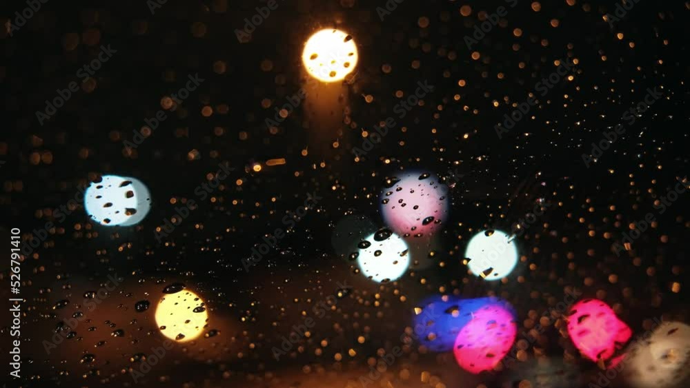 Drops and bokeh lights on the windshield from inside a car and lightning strikes Drops and bokeh lights on the windshield from inside a car and lightning strikes