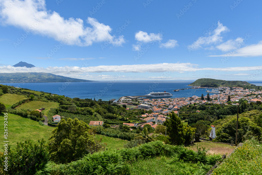 View over Horta to the Pico volcano / View over the town of Horta on the island of Faial, a cruise ship is moored in the harbor, on the horizon you can see the Pico volcano, Azores, Portugal.