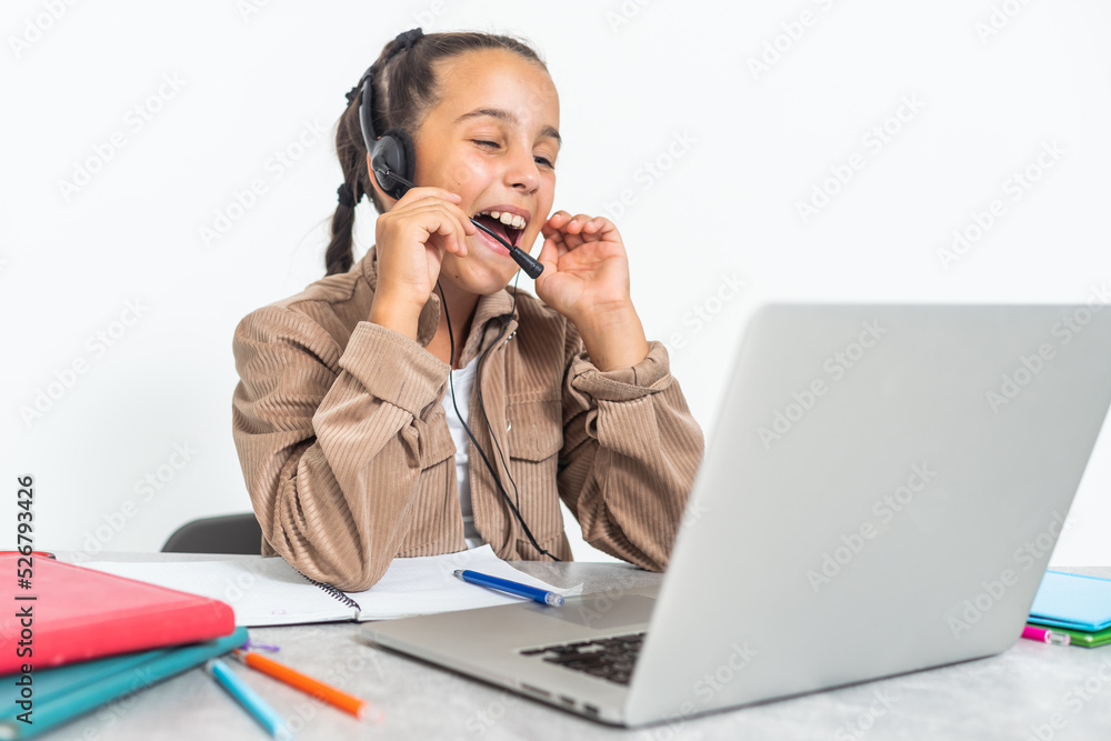 Child online. A little girl uses a laptop video chat to communicate learning while sitting at a table at home. Child online. A little girl uses a laptop video chat to communicate learning while sitting at a table at home.
