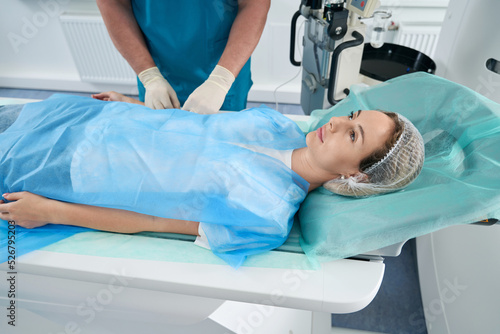 Woman in disposable clothing lies on a medical table