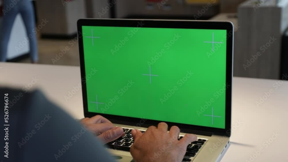 4K Dolly short. Over the shoulder shot of a business man working in office interior on pc on desk, looking at green screen. Office person using laptop computer with laptop green screen, 4K Dolly short. Over the shoulder shot of a business man working in office interior on pc on desk, looking at green screen. Office person using laptop computer with laptop green screen,