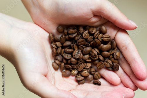 Hands are folded together and holding coffee beans