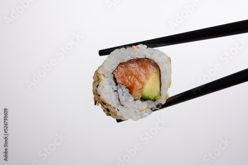 SALMON AVOCADO SUSHI ROLL CHOPSTICK WHITE BACKGROUND 