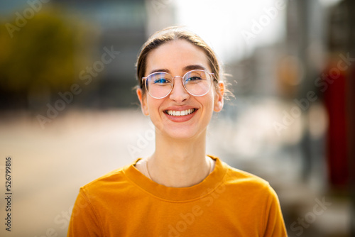 Portrait of attractive young caucasian woman smiling outside