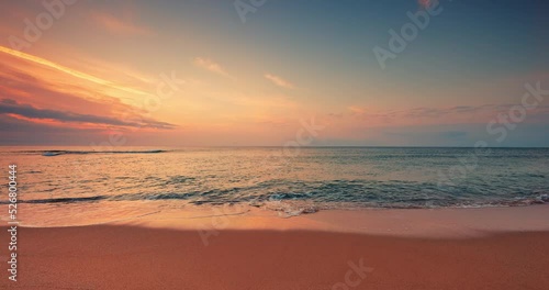 Color sunrise over ocean beach. Splashing sea waves on the coast sand, 4K video of seascape view