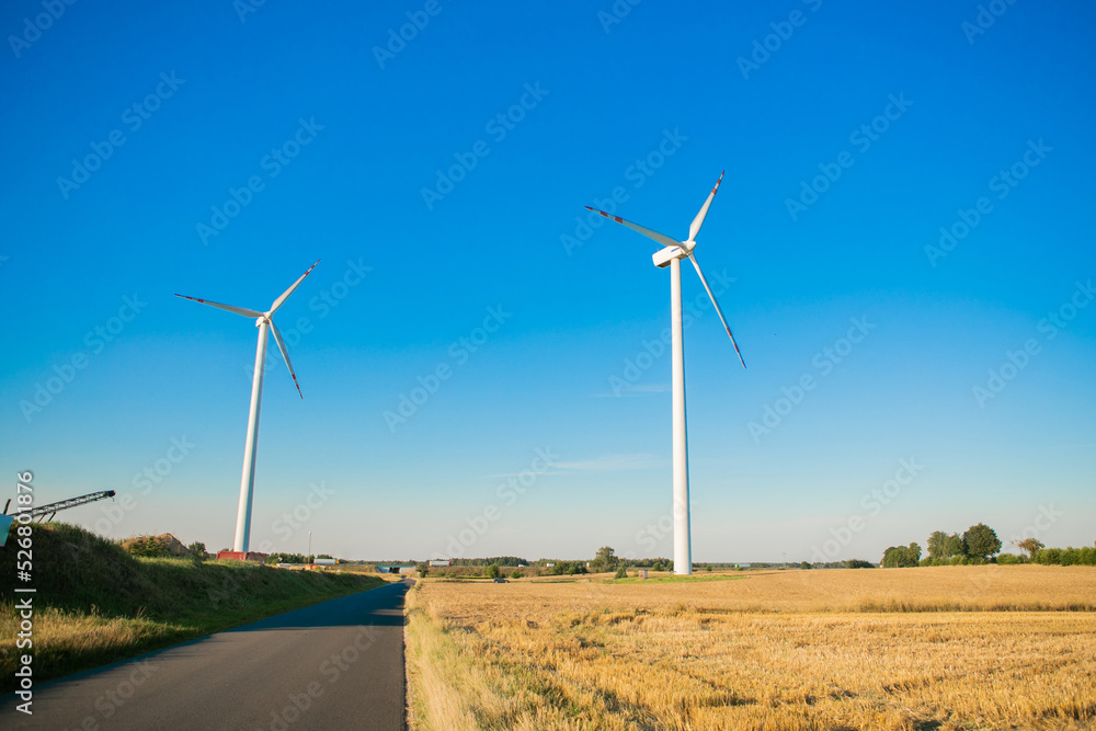 Fototapeta premium Windmills for electricity generation. Green energy concept. Background with copy space for text. Huge blades close up.
