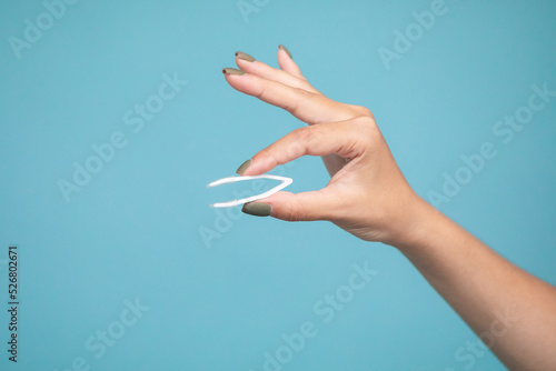 Female hand holding lens tweezers