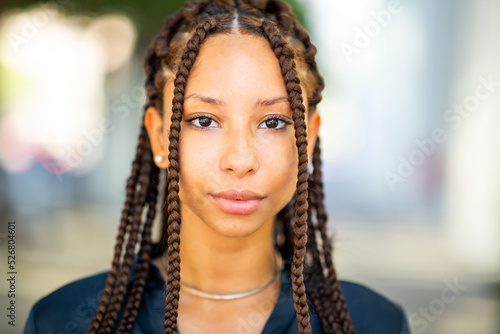 Close up portrait of beautiful young african woman with braided hair outside