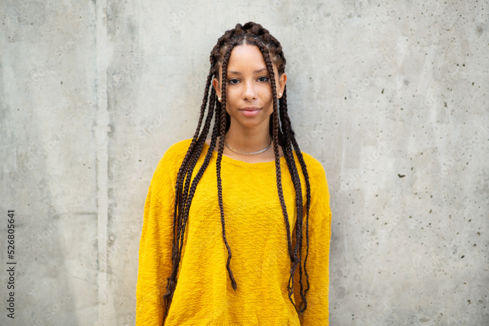Stylish young african woman posing in front of exterior wall Stylish young african woman posing in front of exterior wall